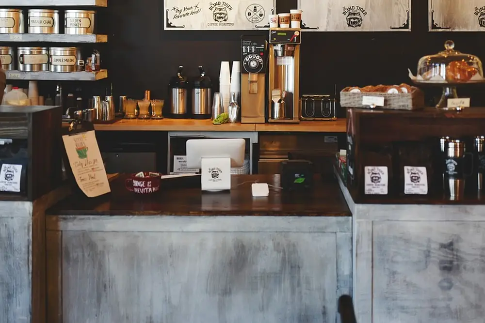 The counter, with tins on the shelf behind and cakes under glass domes