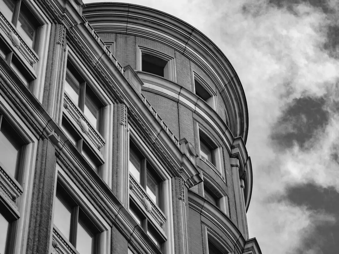 A sandstone tenement facade with a curved bay window running up the building