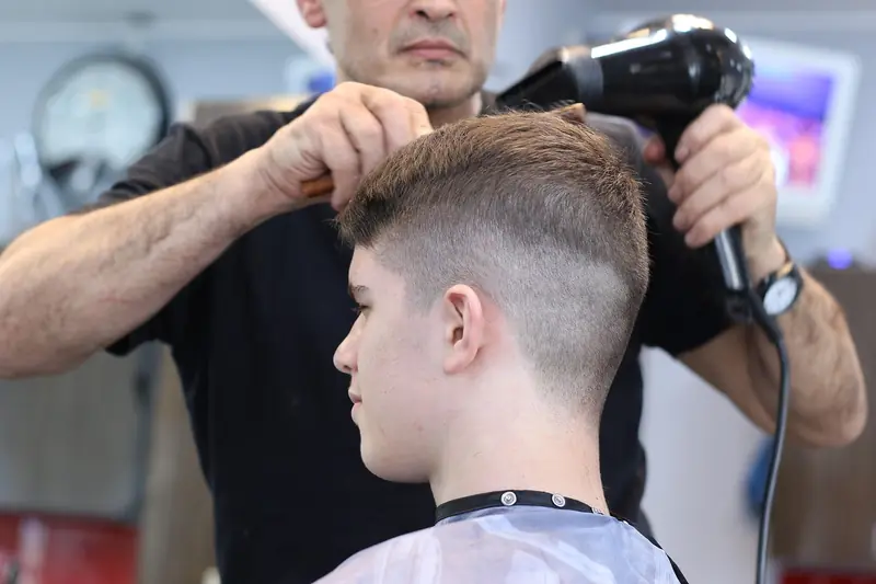 A skin fade being blended with clippers and a dryer