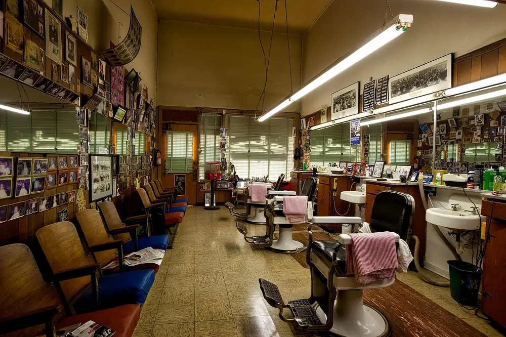The inside of the shop: three chairs, a bench and a wall covered in photographs